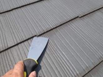 皮スキをスレート屋根に差し込む様子